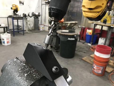This 3D printed drill jig let us precisely drill and tap angled holes in some of our frame components.