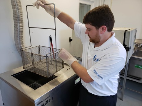 Mechanical Engineer Adam Gosik-Wolfe demonstrates how he puts parts in the Wash