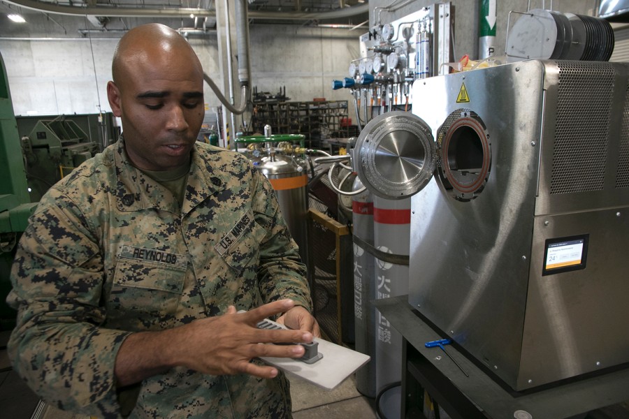 Marine Staff Sgt. Quincy Reynolds of the III Marine Expeditionary Force's 3rd Maintenance Battalion shows off the furnace for the unit's new Markforged Metal X 3D printer at Camp Kinser, Okinawa, Jan. 16, 2020. MATT BURKE/STARS AND STRIPES